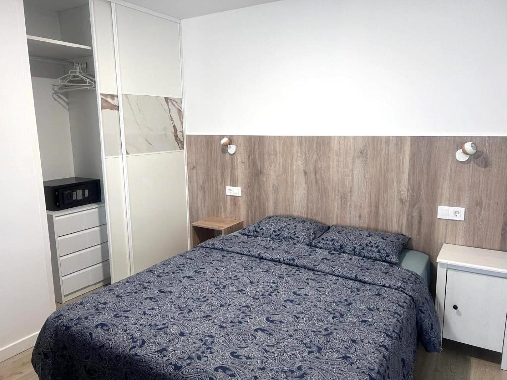 a bedroom with a bed with a blue comforter at Relax apartamento 7 in Las Palmas de Gran Canaria