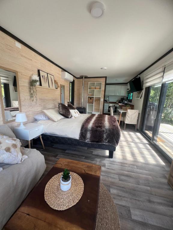 a bedroom with a large bed and a living room at Tiny House 2 a 3 personas Malalcahuello in Malalcahuello