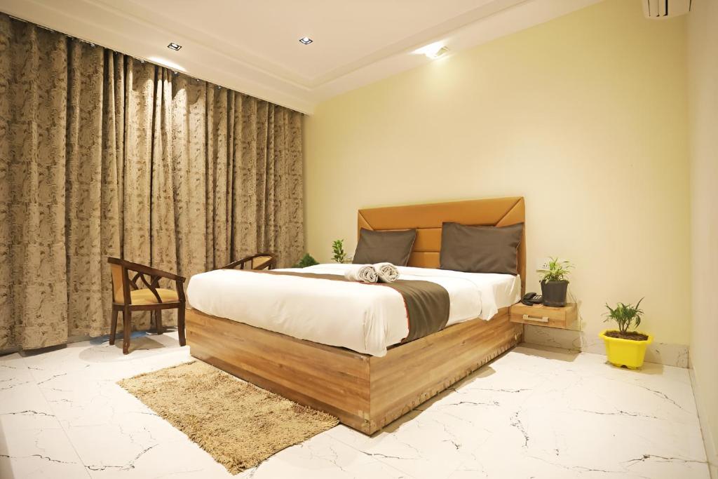 a bedroom with a large bed and a chair at Hotel GOOD LUCK HOUSE Near Delhi Airport in New Delhi