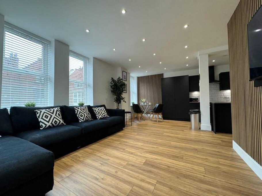sala de estar con sofá negro y cocina en Entire Apartment in Waterloo, en Waterloo