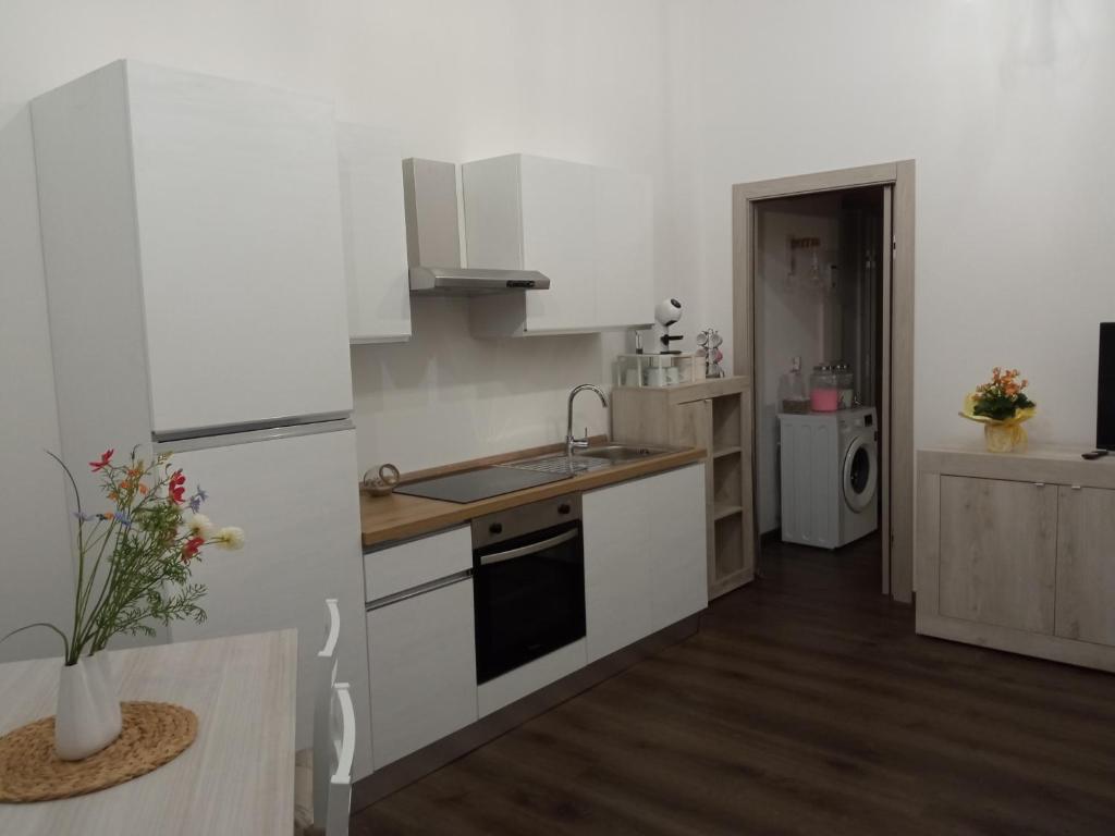 a white kitchen with a sink and a refrigerator at Voyager in Cagliari