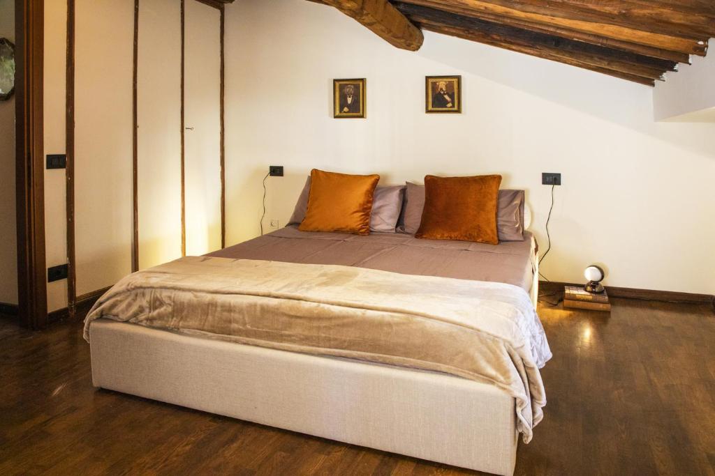 una camera da letto con un grande letto con cuscini arancioni di La Mansardina Beccheria Central Apartment 1 double bedroom, 1 sofa bed a Lucca