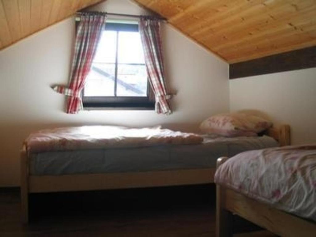 a bedroom with two beds and a window with curtains at Ferienhaus Alpkönigin in Missen mit Garten und Terrasse in Missen-Wilhams