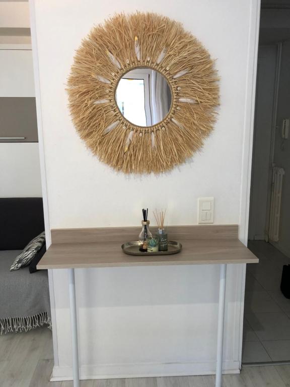 a mirror on a white wall with a table at Studio Residence Du Casino in Menton