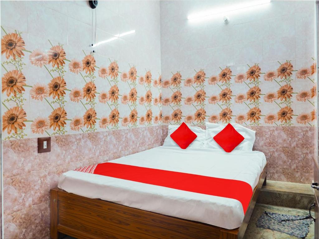 a bedroom with a bed with red pillows at OYO Flagship Ks Elite in Madurai