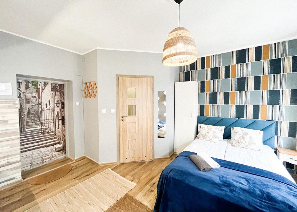 a bedroom with a blue bed with a blue blanket at Apartament Kameralny 13 in Gdańsk