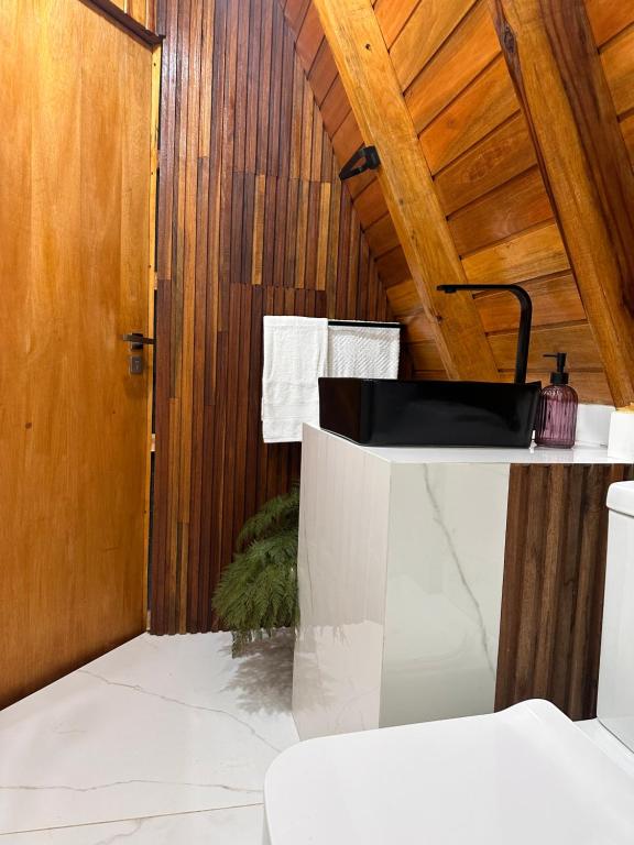 uma casa de banho com um lavatório e um tecto em madeira em Chalé com Cachoeira em Witmarsum
