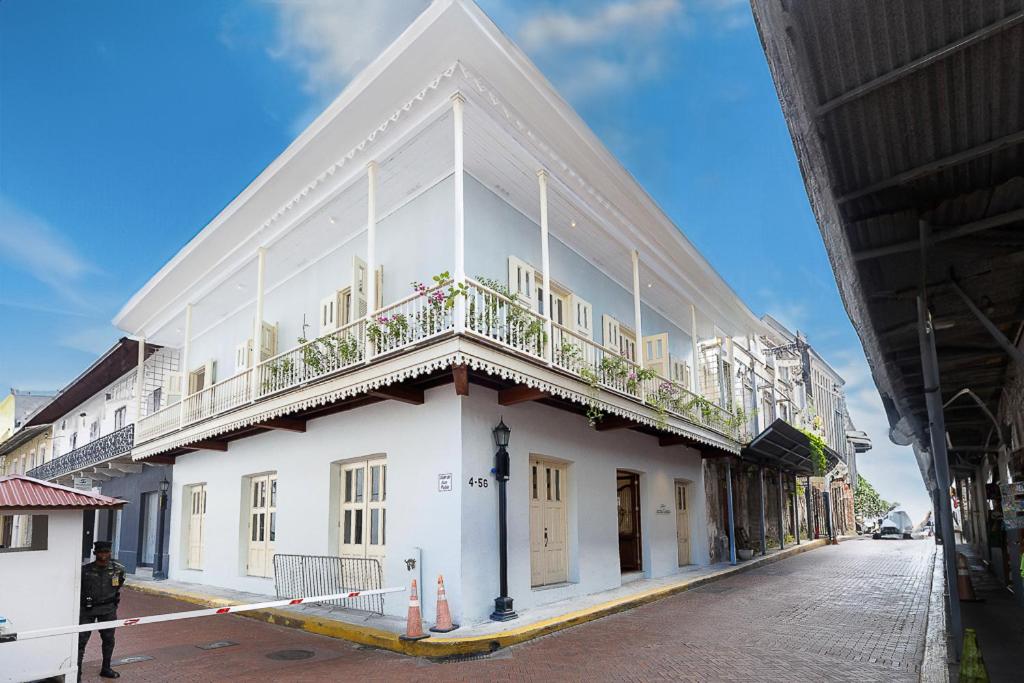 um edifício branco com uma varanda em cima em Casa Acomodo Casco Viejo 4bdr Historic Mansion na Cidade do Panamá