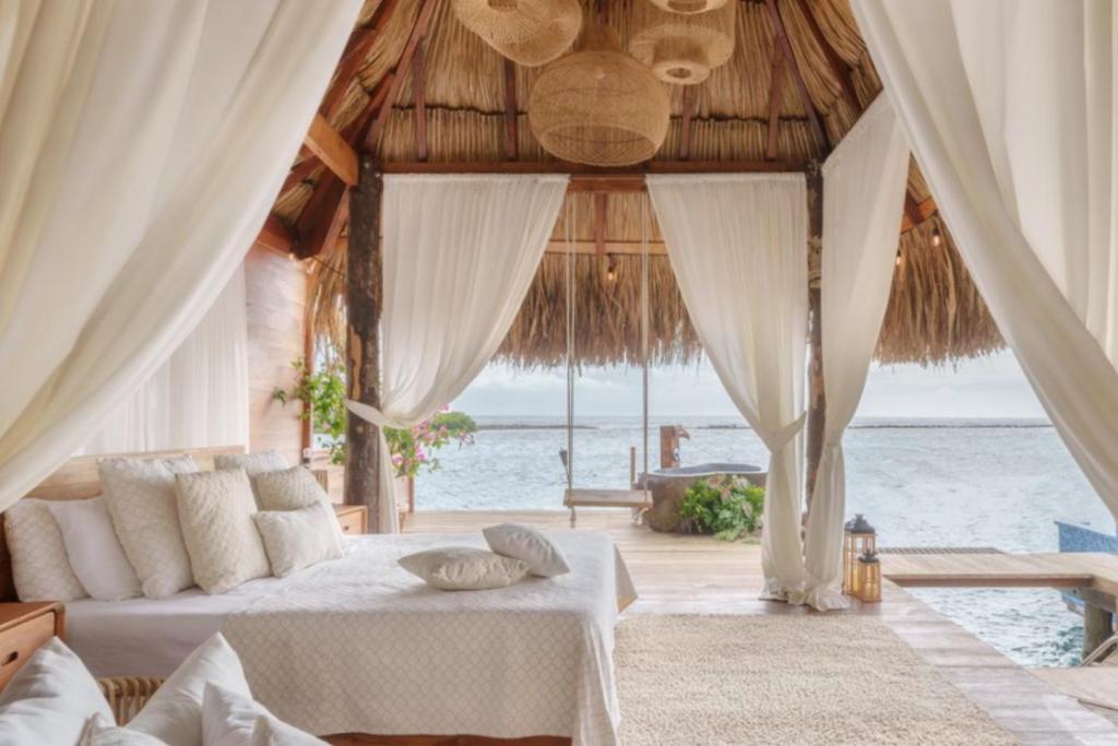 a bedroom with a bed and a view of the ocean at Villa with salt pool Aruba in Savaneta