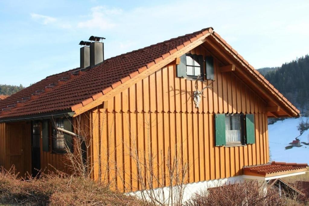 una pequeña casa de madera con una ventana verde en Ferienhaus Alpkönig in Missen mit Garten und Terrasse, en Missen-Wilhams