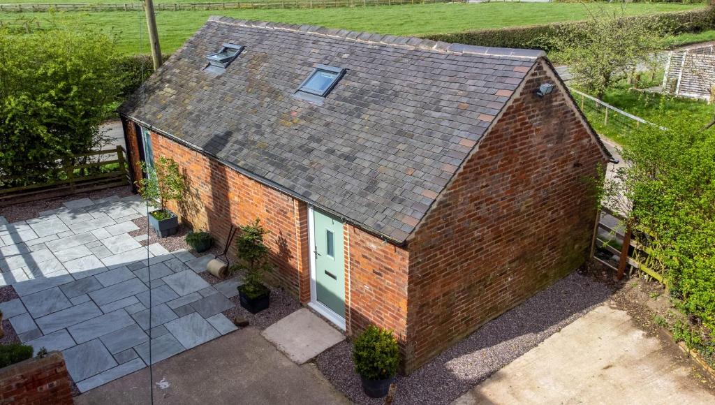 an overhead view of a brick building with a green door at The Den by StayStaycations in Rugeley