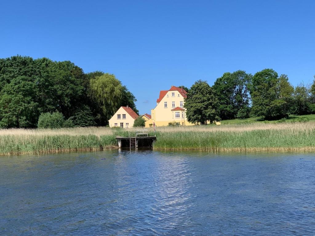 a house on the side of a river with a house at Wohnung im Erdgeschoss des Herrenhauses in Neuenkirchen