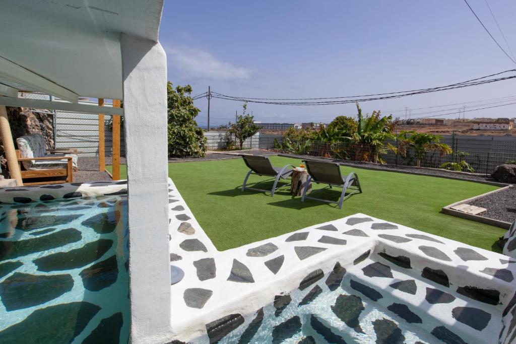 a dog sitting in two chairs next to a swimming pool at Finca La Gloria in Telde