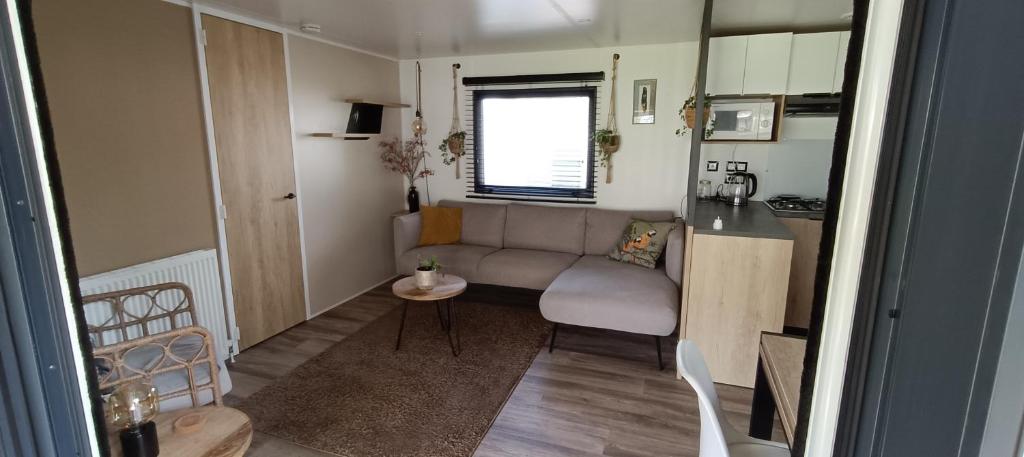 een kleine woonkamer met een bank en een tafel bij Chalet Cozy Cove te Lauwersoog in Lauwersoog