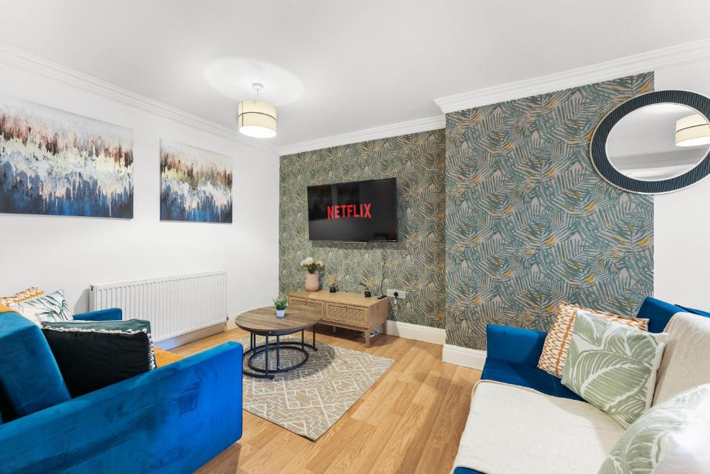 a living room with blue furniture and a tv at Secret Abode in Harrogate in Harrogate