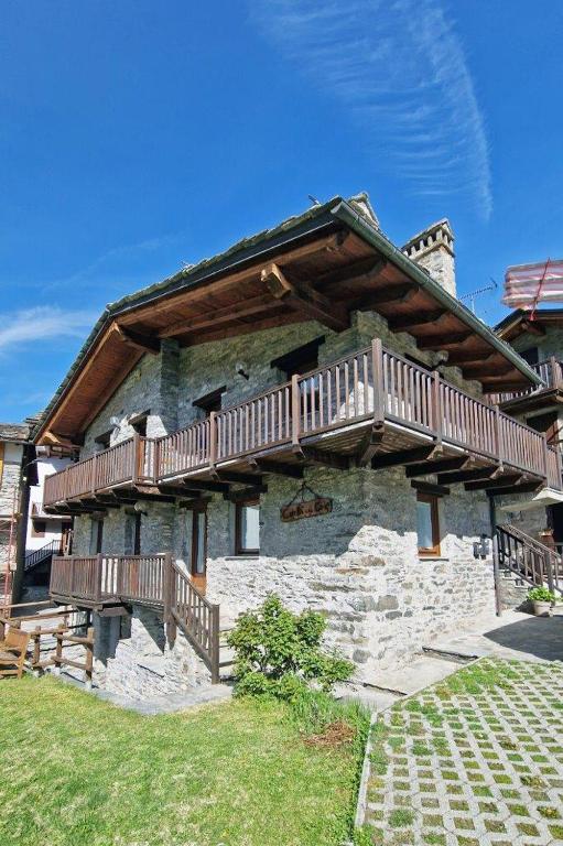 a house with wooden decks on the side of it at Maison Crè in La Salle
