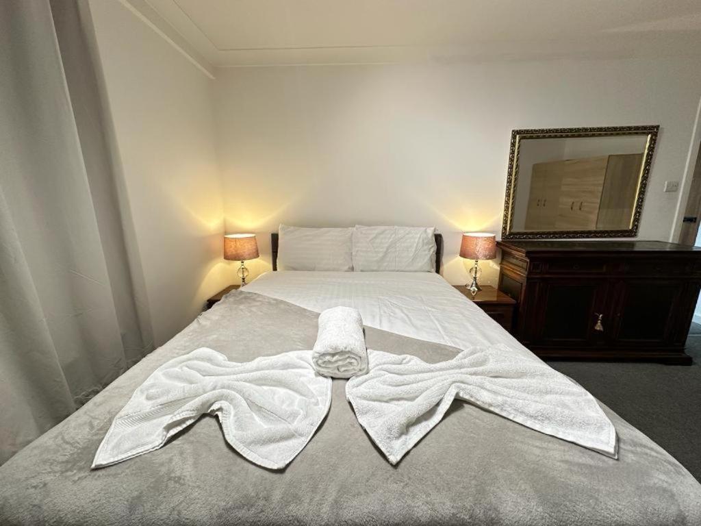 a bedroom with a bed with a robe on it at Two Bedroom Apartment Near Park Lane in London