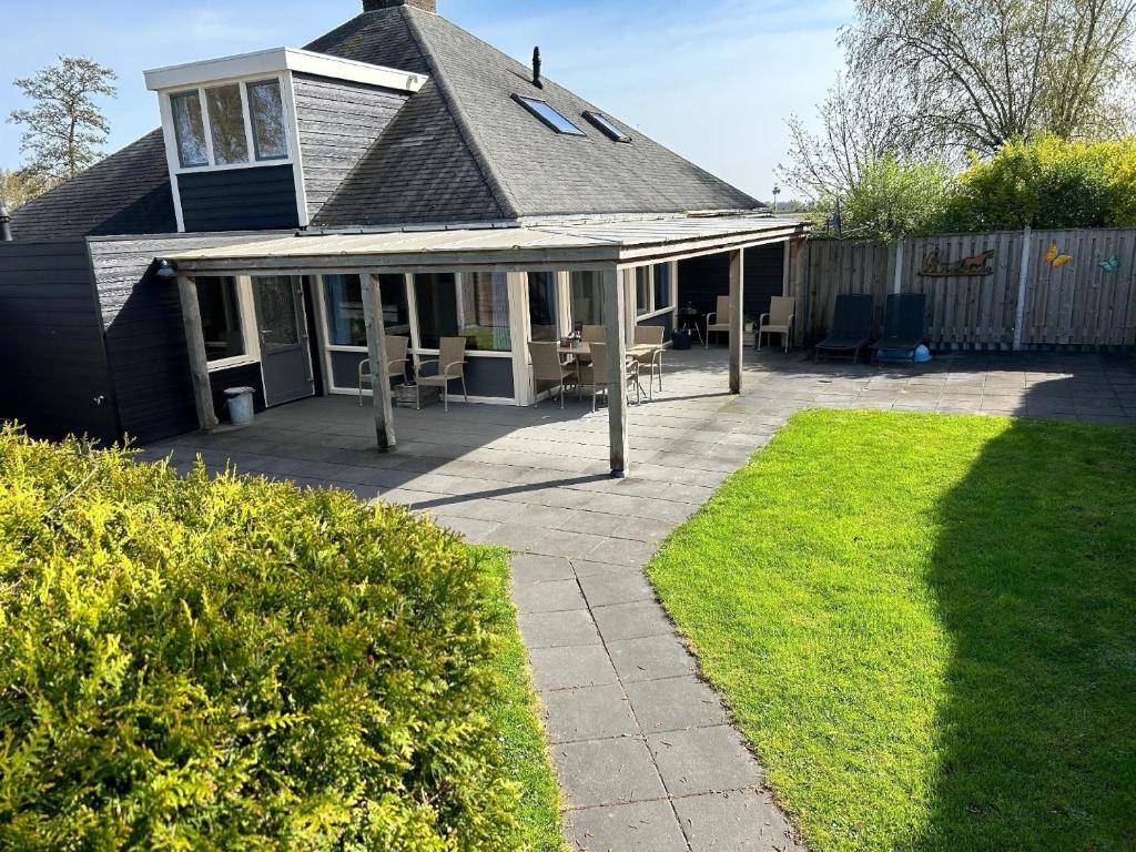 uma casa com um pátio e um quintal em Ferienhaus für 5 Personen ca 70 qm in Stavenisse, Zeeland Küste von Zeeland em Stavenisse
