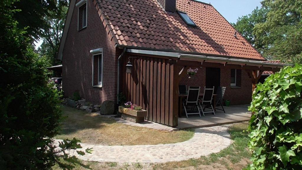 a house with a deck and chairs on it at Ferienhaus mit überdachter Terrasse und Carport in Walsrode