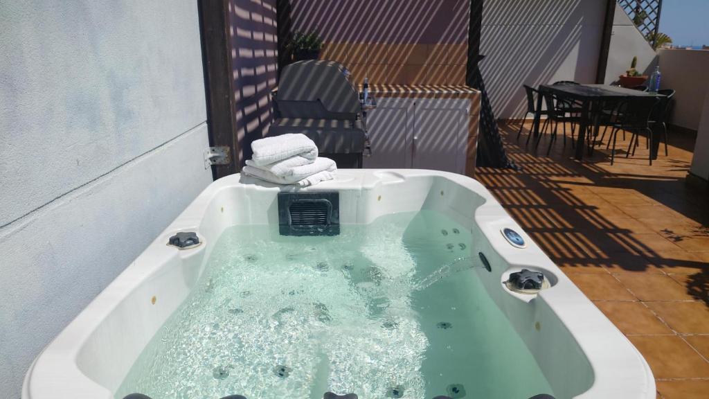 a bath tub with towels in it on a patio at Carmen Apartamento Millón - Private roof terrace with Jacuzzi & BBQ in Nerja