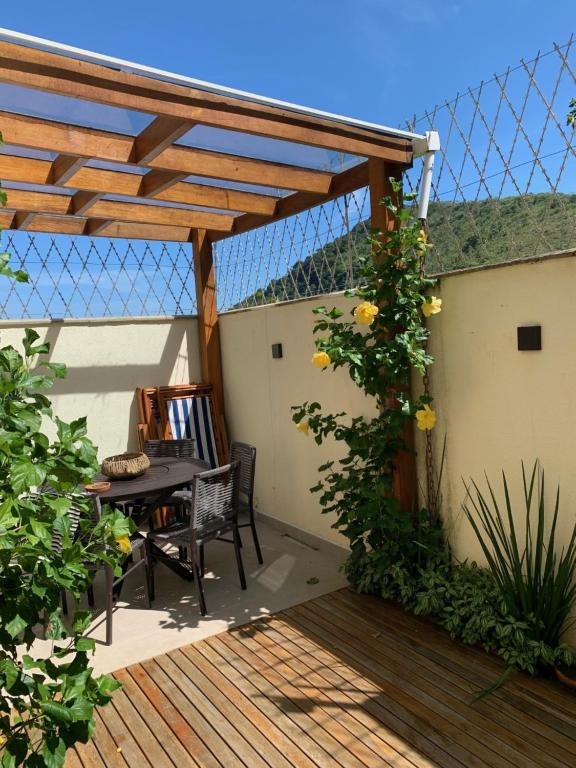 a pergola with a table and chairs on a patio at Casa na Praia de Santiago, próxima a Maresias! in São Sebastião