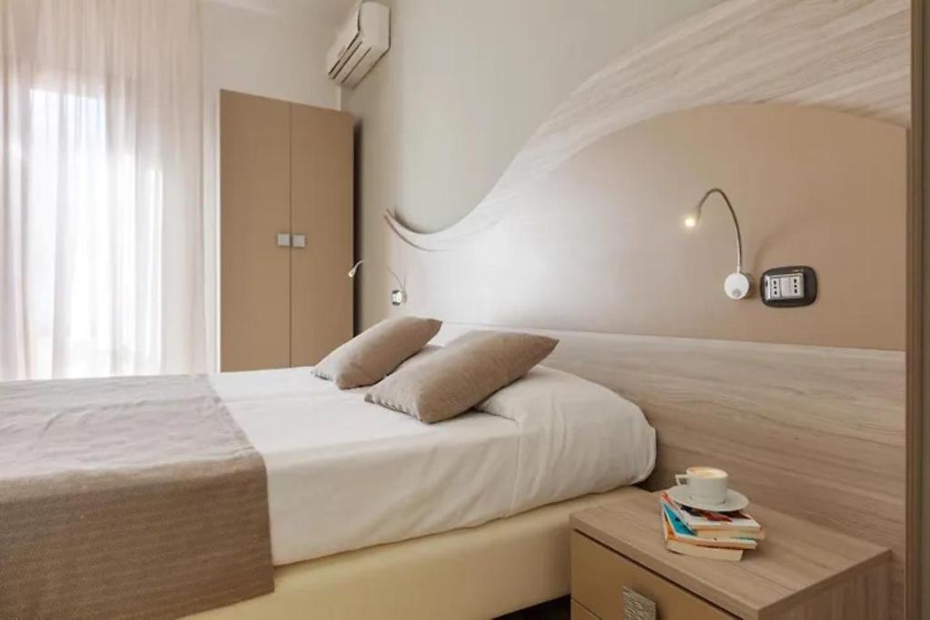 1 dormitorio con 1 cama y 1 mesa con libros en La Conchiglia sul mare Hotel en San Vito lo Capo