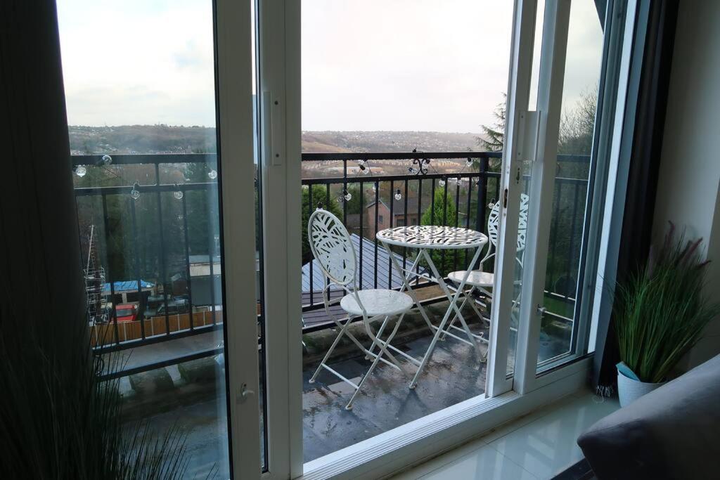a balcony with a table and chairs on a balcony at Two-Bedroom Apartment with Scenic Balcony View in Shipley