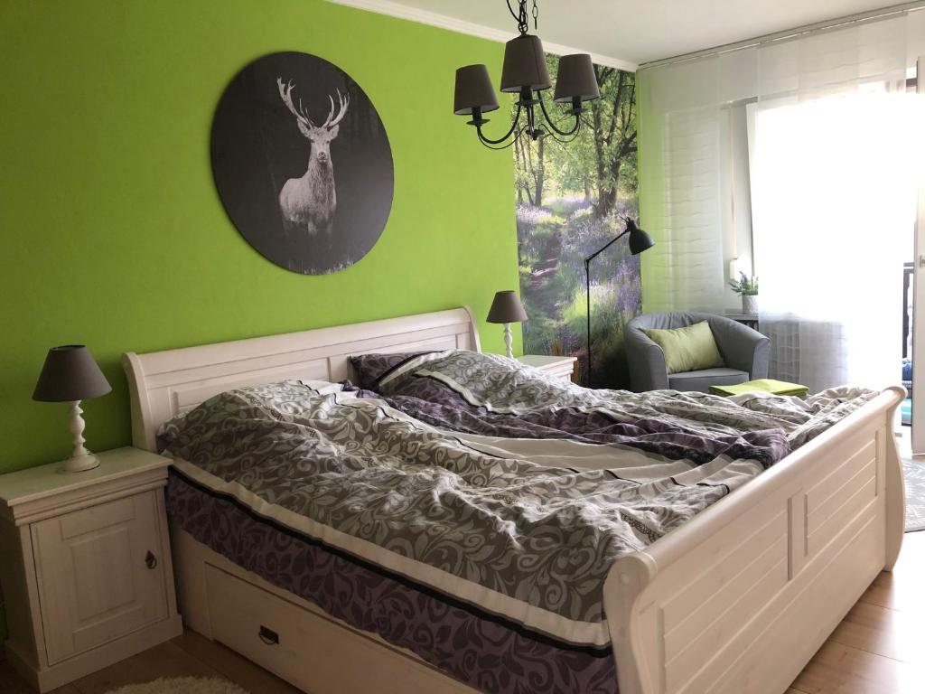 um quarto com uma cama e uma parede verde em Gaishoellpark em Sasbachwalden