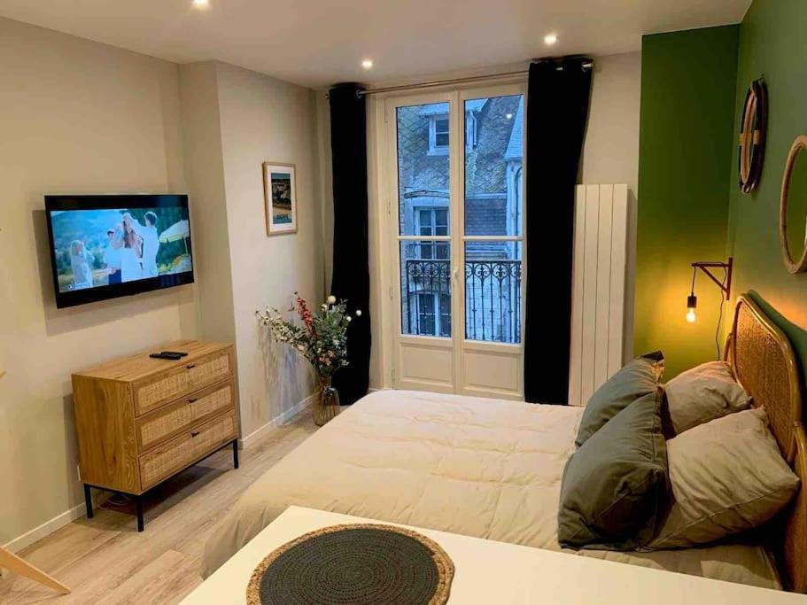 une chambre avec un lit, une télévision et une fenêtre dans l'établissement Terasse avec superbe vue sur le marché de Dieppe, à Dieppe