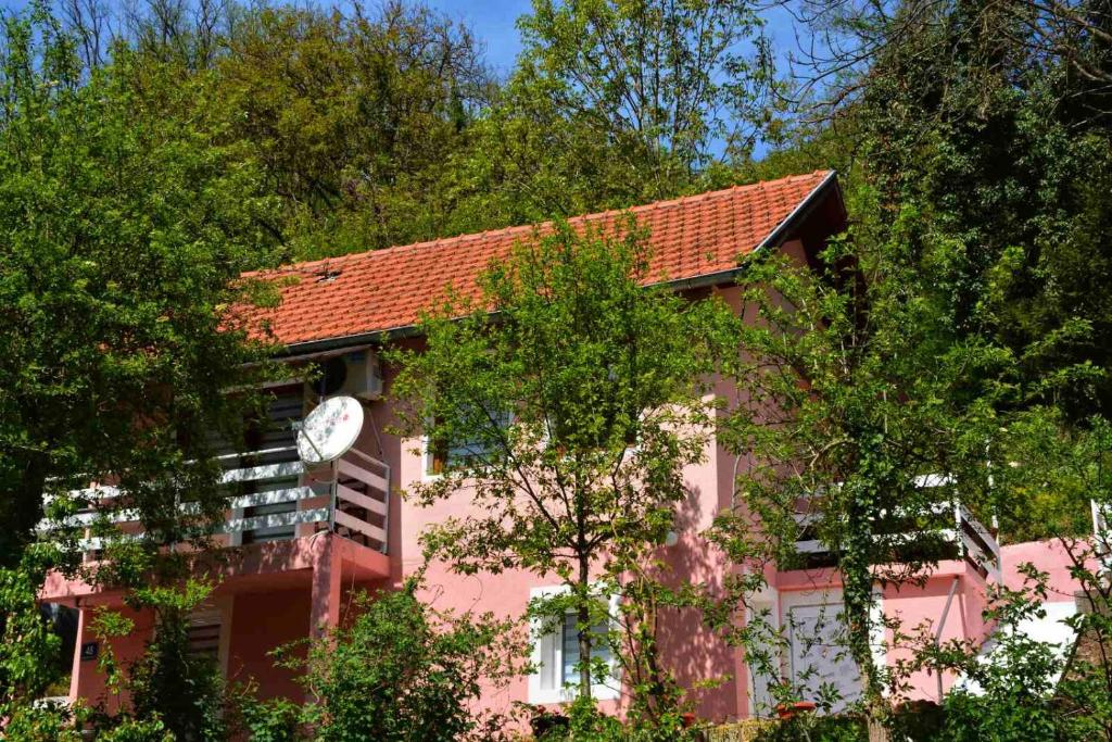 un edificio rosa con un orologio sul lato di Dodir prirode a Višegrad