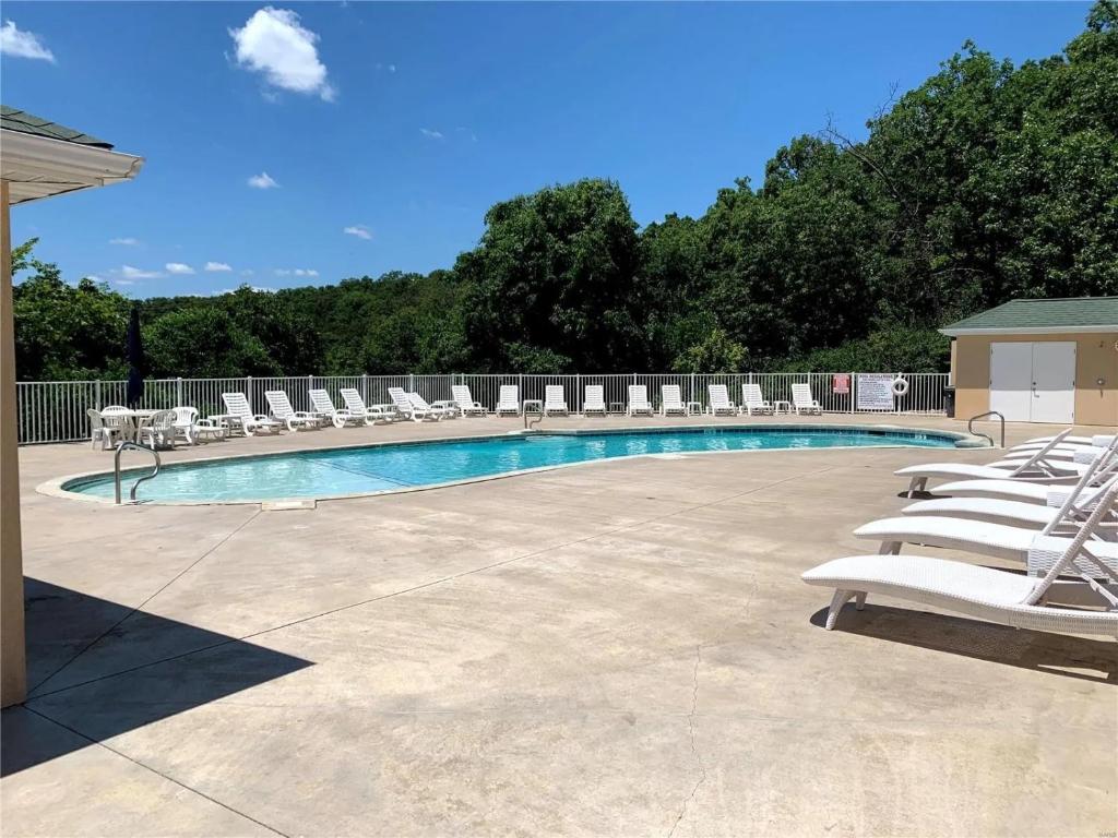 奥沙克湖The best lake view in Ozark.的一组躺椅和一个游泳池