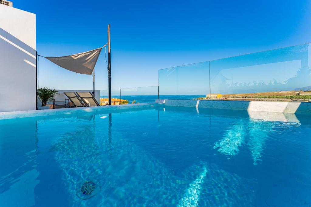 a swimming pool with a view of the ocean at Green House - Modern Villa in Tenerife, Spain in Guía de Isora