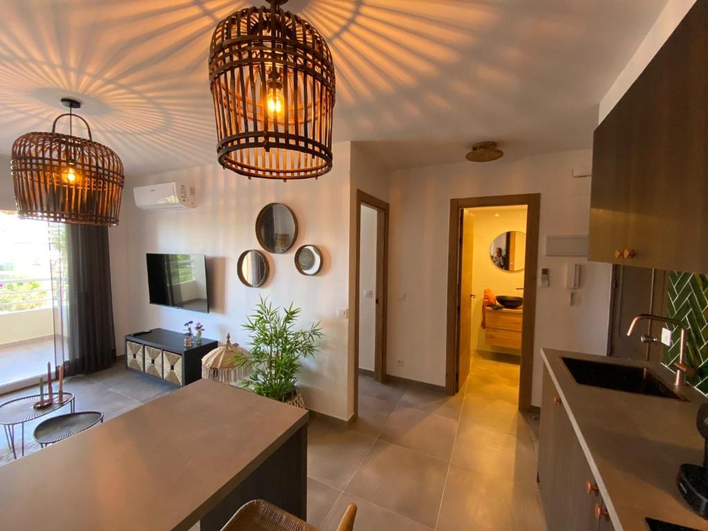 cocina con 2 lámparas de araña y sala de estar en Calpe Apolo V 3B Appartement Marrakech Style, en Calpe