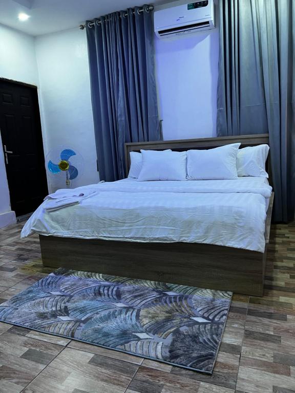 ein Schlafzimmer mit einem großen Bett mit einem Teppich in der Unterkunft Close 5 in Garki