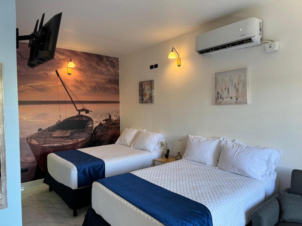 um quarto de hotel com duas camas e uma televisão em Apartaestudios La capital em San José