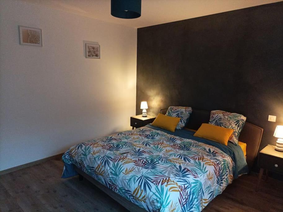 una camera da letto con un letto con due cuscini sopra di Le P'tit Courtil - Maison à la campagne a Plédran