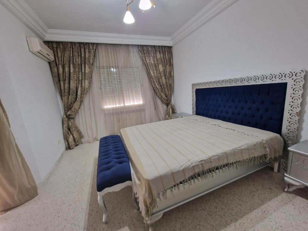 1 dormitorio con 1 cama azul y 1 silla azul en Dar Salem III en Túnez