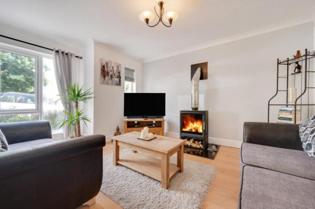 a living room with a couch and a fireplace at 3 Bed Holiday Home in Llandeilo with log burner in Llandeilo