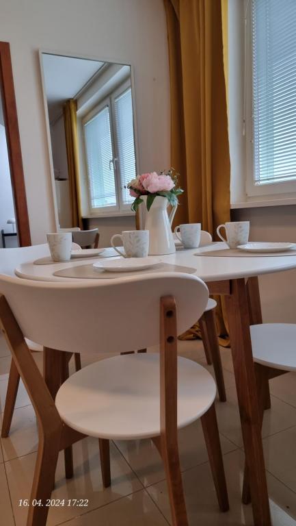 una mesa con dos sillas y un jarrón con flores. en Turecka 49 en Nové Zámky