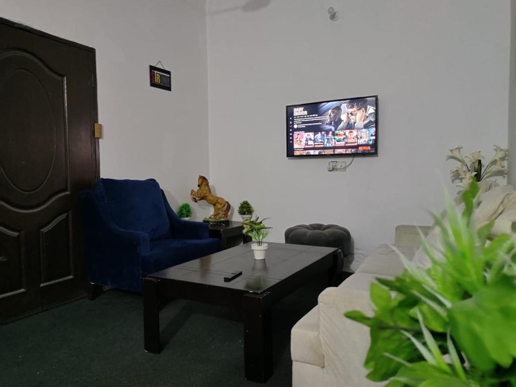 Syedah 's Homestay في لاهور: غرفة معيشة مع أريكة وطاولة قهوة
