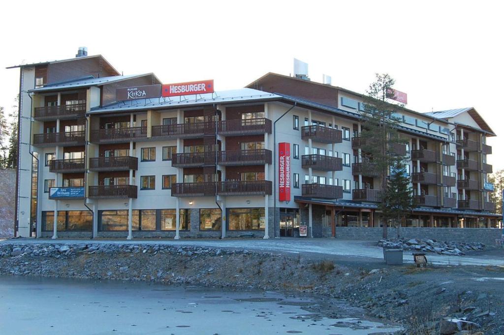 a large building with balconies next to a body of water at Ruka Chalets Royal Apartments in Ruka