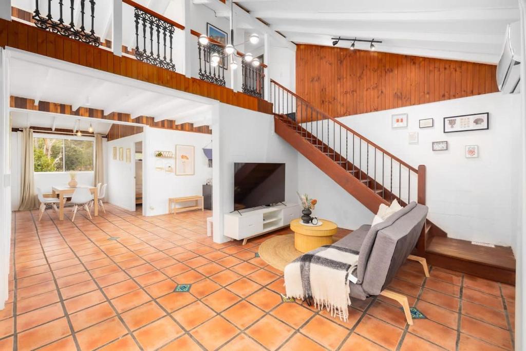 a large living room with a staircase and a television at Reconnect with nature at this unforgettable escape in Gold Coast