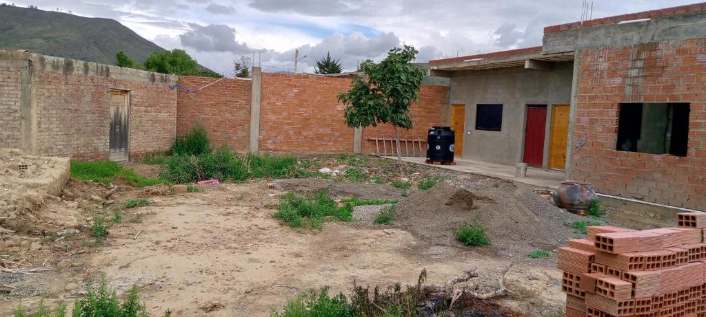 a brick building with a lot of dirt in front at Casa de campo vidal in Cochabamba