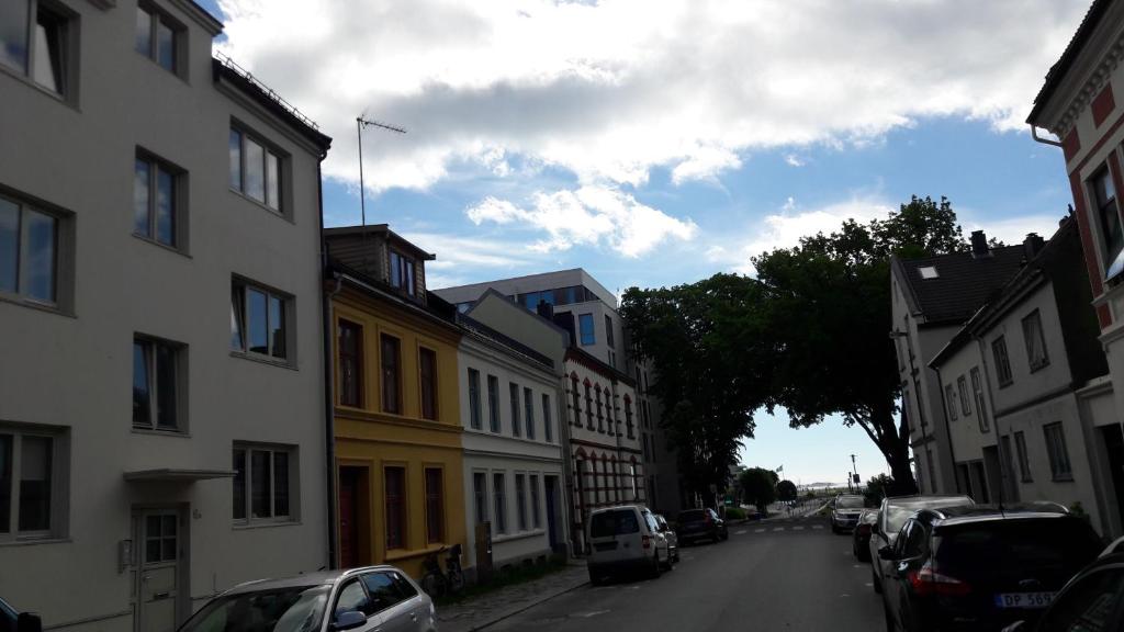 a city street with buildings and cars parked on the street at Apartment Bystranda - City Beach in Kristiansand