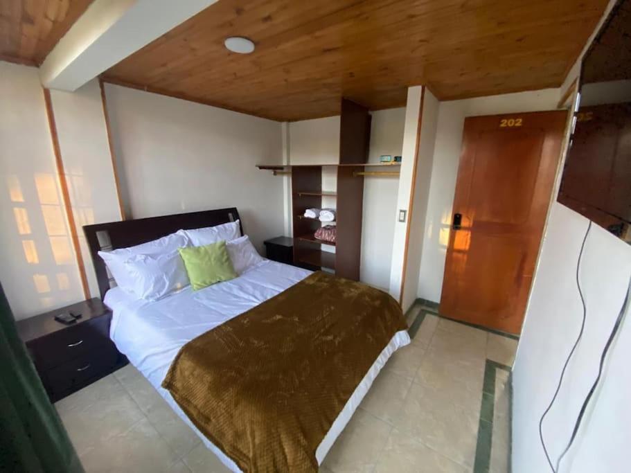um quarto com uma cama com uma almofada verde em Santamaria Lago Home em Bogotá