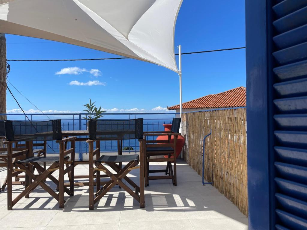 a patio with a table and chairs and an umbrella at Emerald in blue in Loutraki