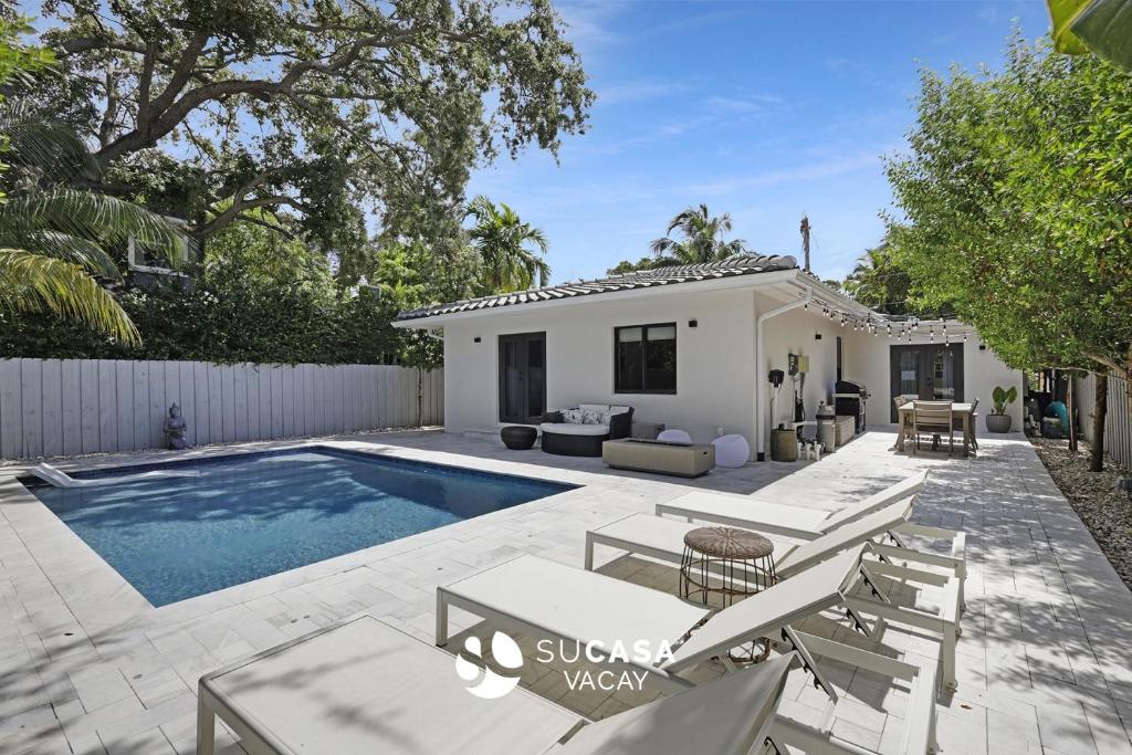 a backyard with a pool and a house at Designer Home w Pool & Firepit - 7 min to Brickell in Miami