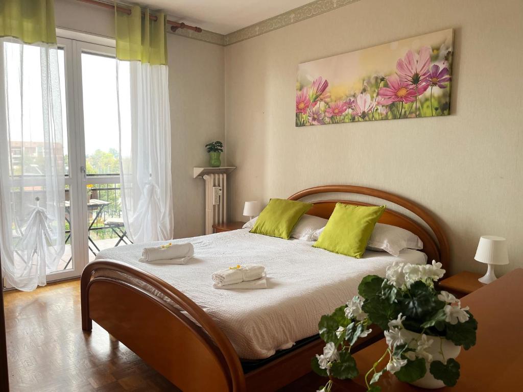 ein Schlafzimmer mit einem großen Bett mit grünen Kissen in der Unterkunft Comfort living apartment in Orbassano