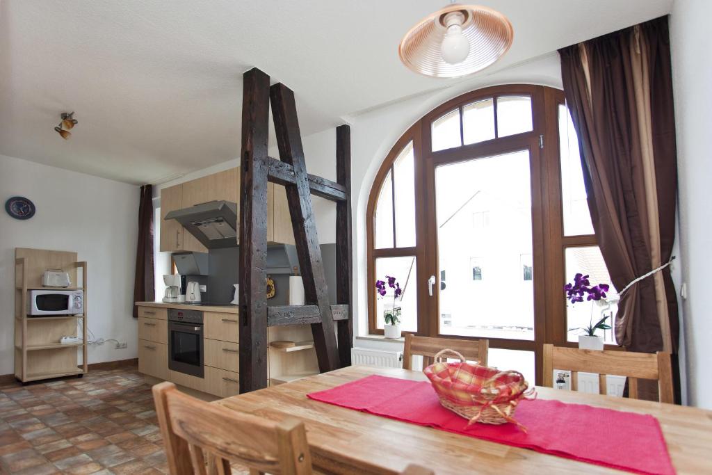 a kitchen and dining room with a table and a large window at Ferienwohnung Auszeit in Bad Berka