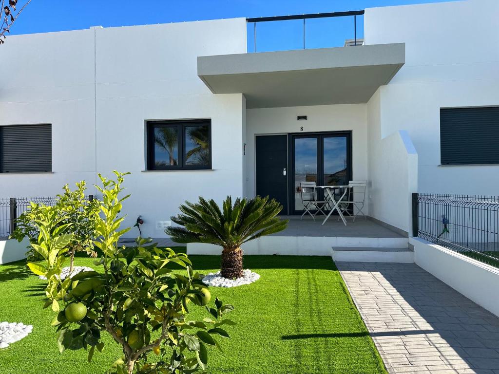 een wit huis met een tuin met groen gras bij Villa Lagarto - Denia El Verger in Denia